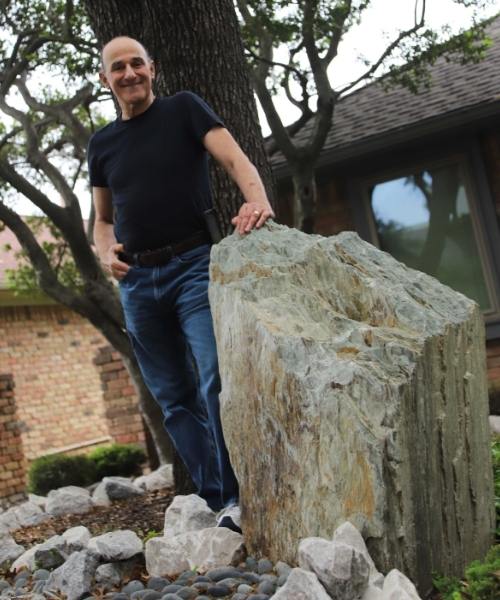 Master Gardener Barry Bloom stand next to the Cloud Schist Boulder in his front yard.